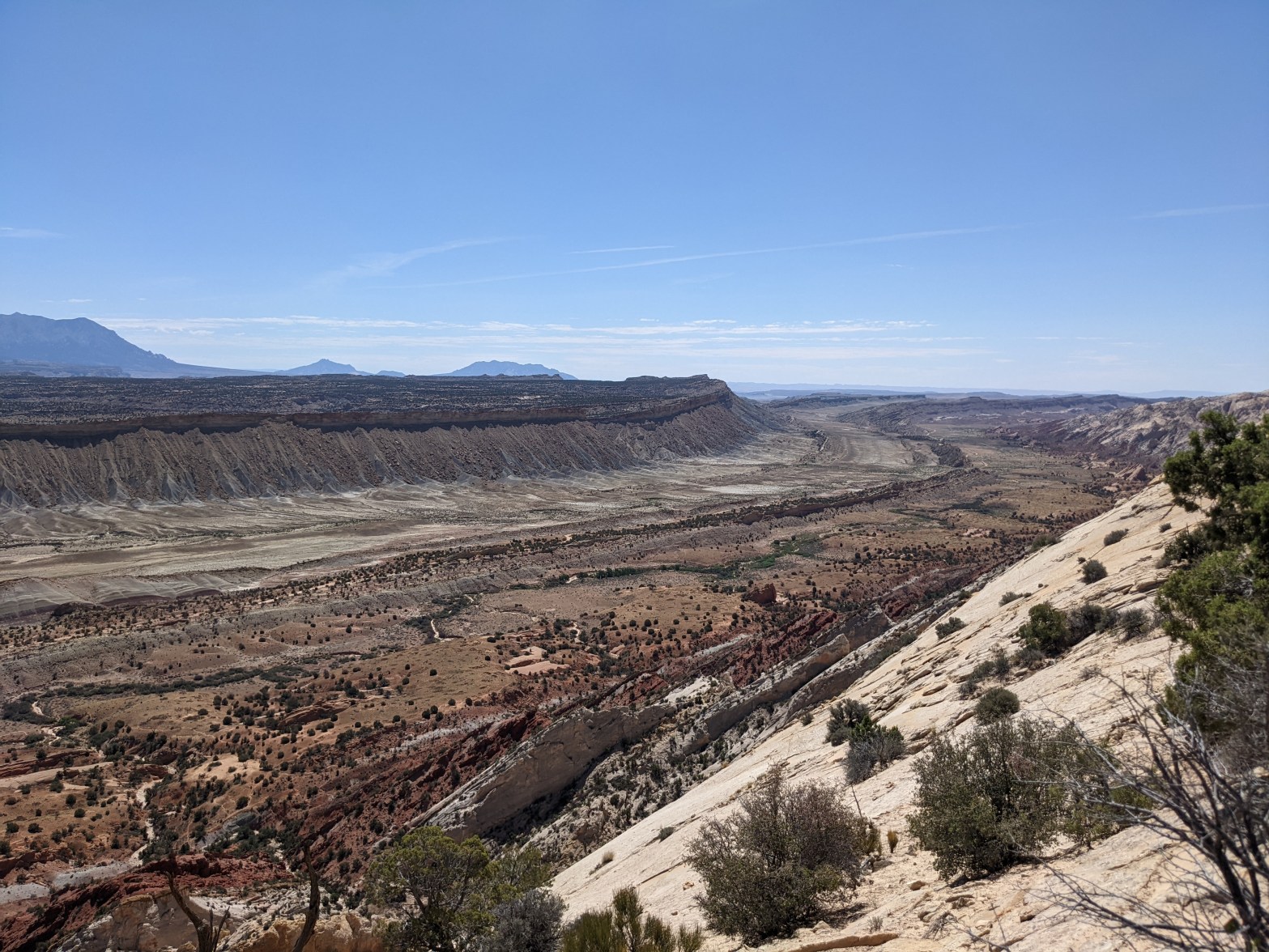 Decorative image showing blue sky and a valley with many sedimentary layers of rock.